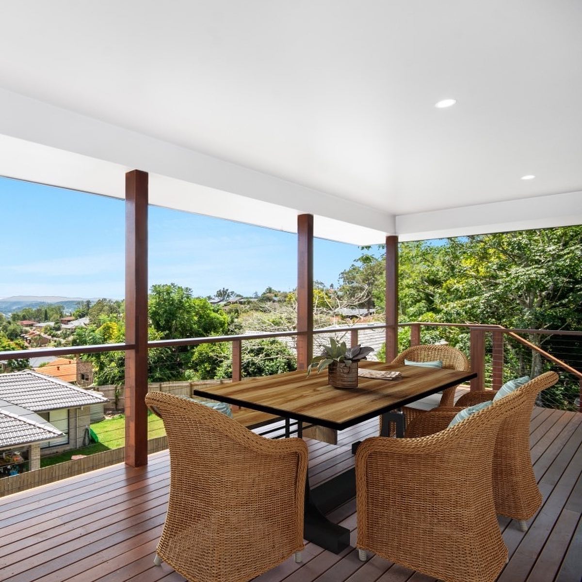 Freshly painted covered outdoor deck with white ceiling, timber posts and wire balustrade overlooking a leafy valley by R J Britt Painting in Lismore, NSW