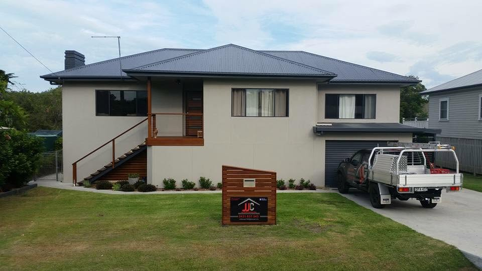 Two-storey home with freshly painted cream rendered walls, charcoal roof and timber stair detailing by R J Britt Painting in Yamba
