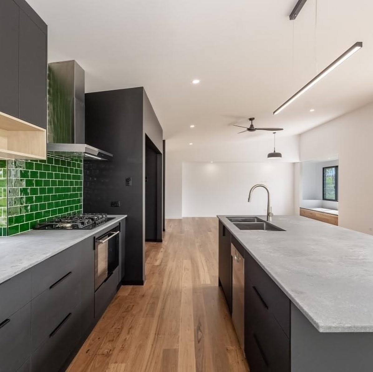 Modern kitchen with charcoal cabinetry, white walls and green tiled splashback painted by R J Britt Painting in Lismore, NSW
