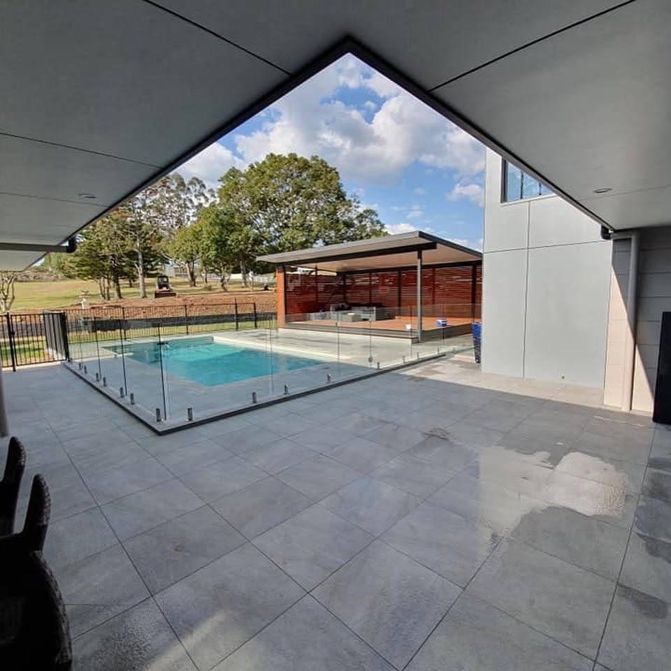 Exterior repaint of a modern poolside home with rendered walls and painted eaves by R J Britt Painting in Lismore, NSW