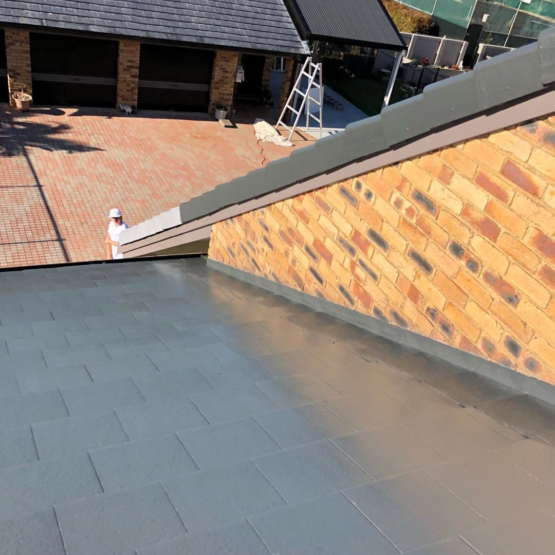 Roof painting with freshly recoated grey tiles beside brickwork by R J Britt Painting in Lismore, NSW