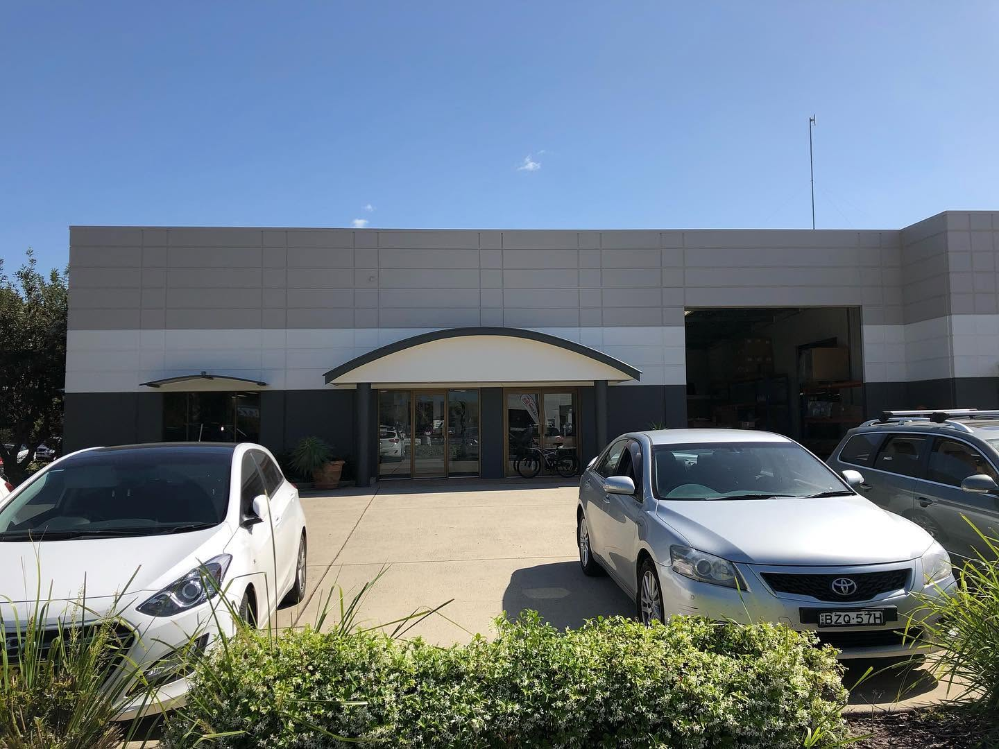 Commercial warehouse and office building with freshly painted grey and charcoal exterior by R J Britt Painting in Lismore, NSW
