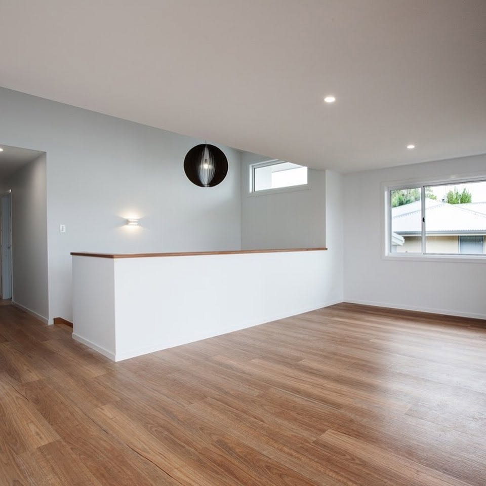 Freshly painted open living room with white walls, timber floors and black pendant light by R J Britt Painting in Tweed Heads