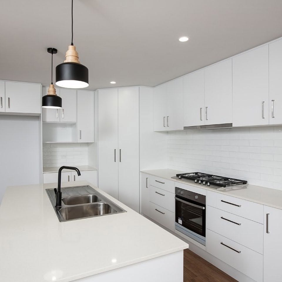 Freshly painted white kitchen with subway tile splashback and black pendant lights by R J Britt Painting in the Northern Rivers, NSW