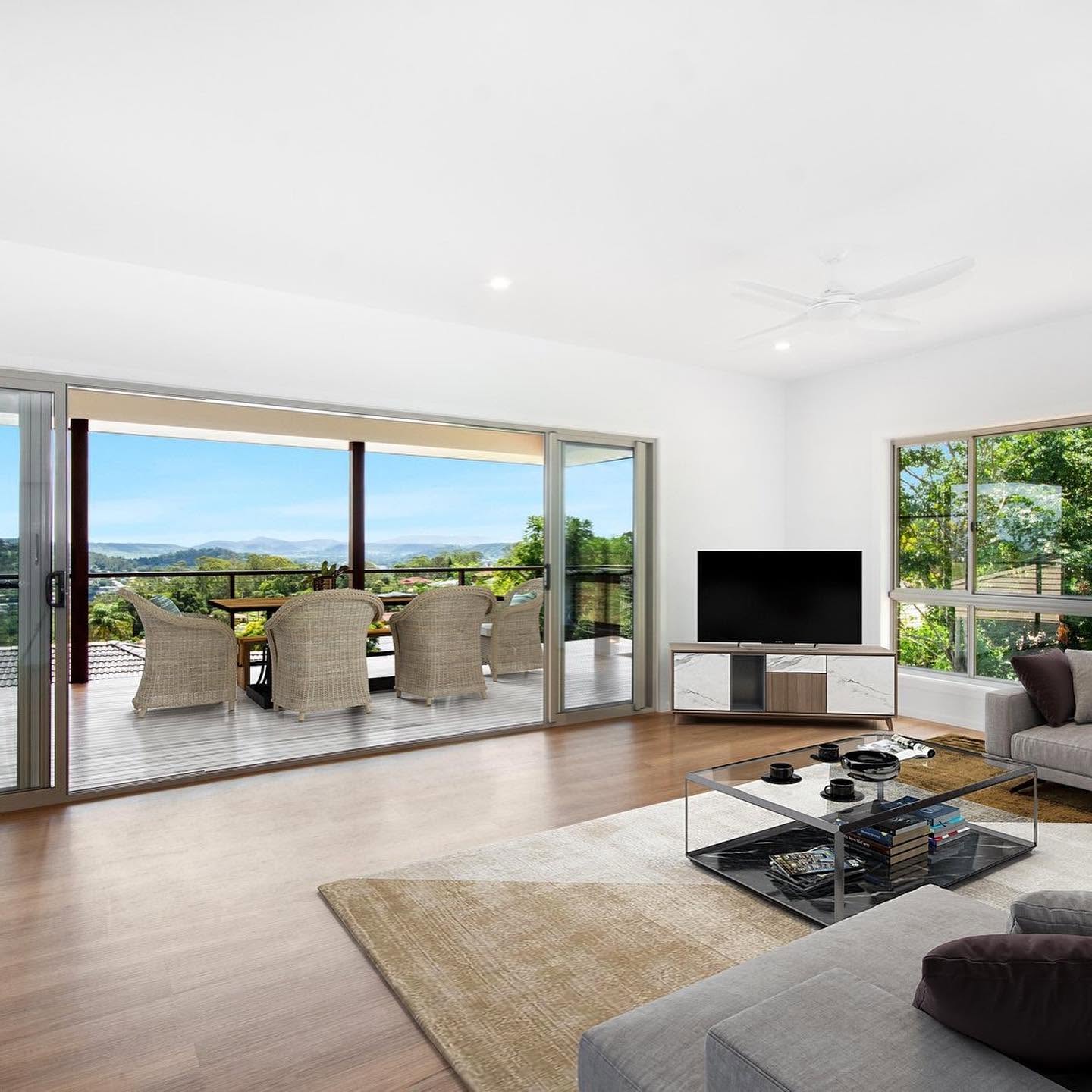 Freshly painted open-plan living room with white walls and ceiling opening onto a deck by R J Britt Painting in Lismore, NSW
