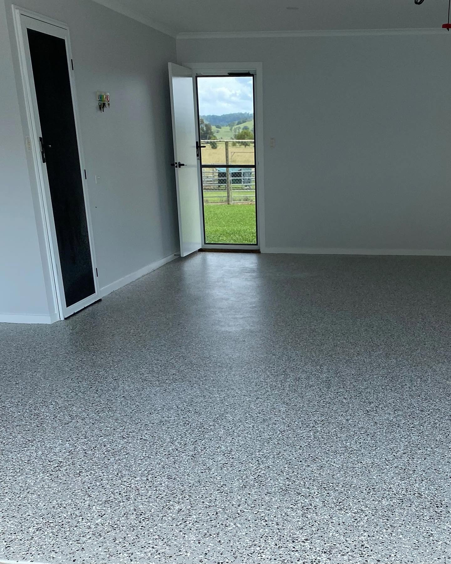 Two-pac flake epoxy floor coating with grey speckled finish in a garage by R J Britt Painting in Lismore, NSW