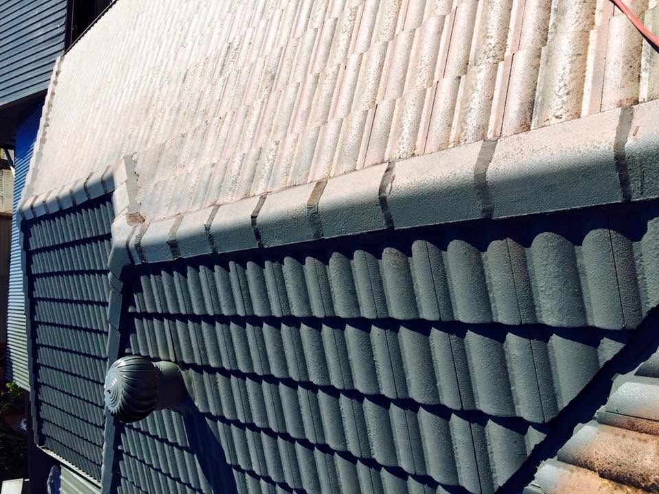 Half-restored tile roof showing freshly painted charcoal tiles beside weathered tiles by R J Britt Painting in Lismore, NSW